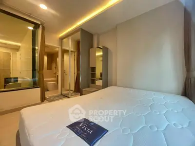 Modern bedroom with ensuite bathroom and large mirror closet in luxury apartment.