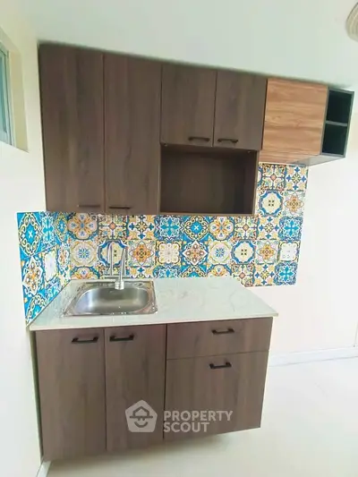 Charming kitchen with colorful tile backsplash and modern cabinetry