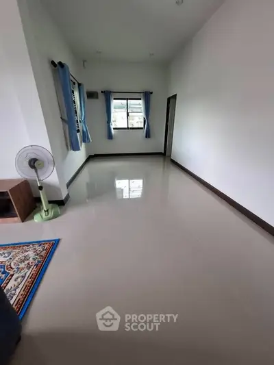 Spacious empty room with glossy tiled floor and blue curtains, ideal for customization.