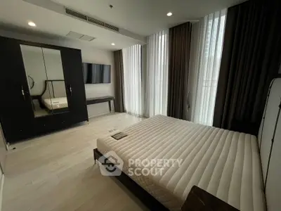 Spacious modern bedroom with sleek furniture and large windows for natural light.