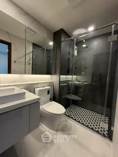 Modern bathroom with sleek design, glass shower enclosure, and stylish fixtures.