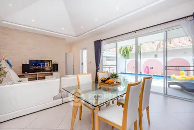 Spacious living room with pool view, modern furniture, and natural light in a luxurious home.