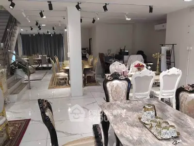 Luxurious open-plan living and dining area with elegant furniture and marble flooring.