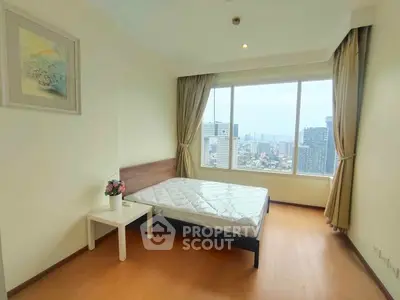 Bright bedroom with large window offering stunning city views, featuring a minimalist design and cozy atmosphere.