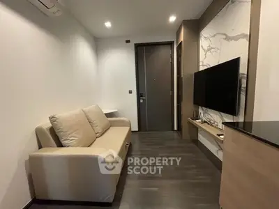 Modern living room with sleek design, featuring a comfortable sofa and wall-mounted TV, perfect for relaxation.