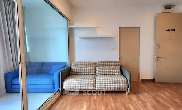 Cozy living room with checkered sofa and wooden flooring, ideal for modern urban living.