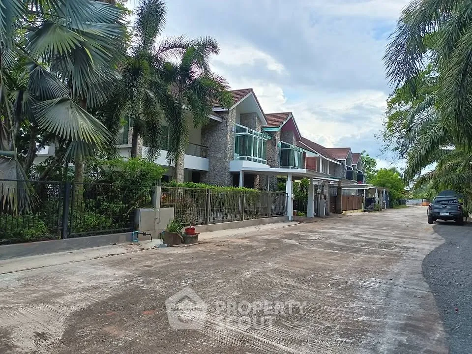 Charming suburban row houses with lush greenery and spacious driveways.
