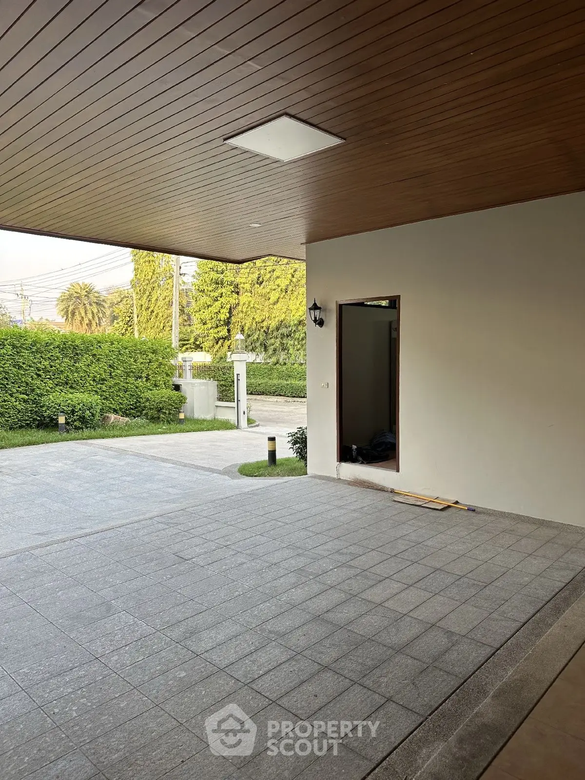 Spacious modern parking area with wooden ceiling and lush greenery