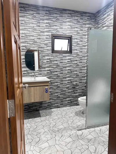Modern bathroom with stylish tile design and glass shower partition.