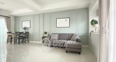 Spacious living room with elegant decor and dining area, featuring modern furniture and natural light.