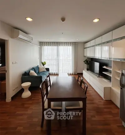 Spacious living room with modern furniture and natural light in a stylish apartment.