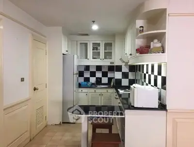 Charming kitchen with black and white checkered backsplash and modern appliances