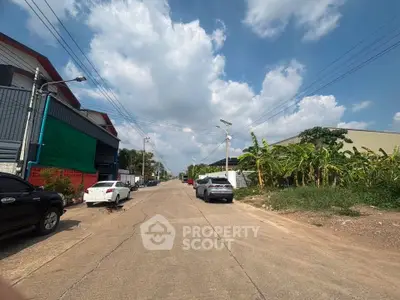 Scenic street view with clear skies and surrounding greenery, ideal for real estate development.