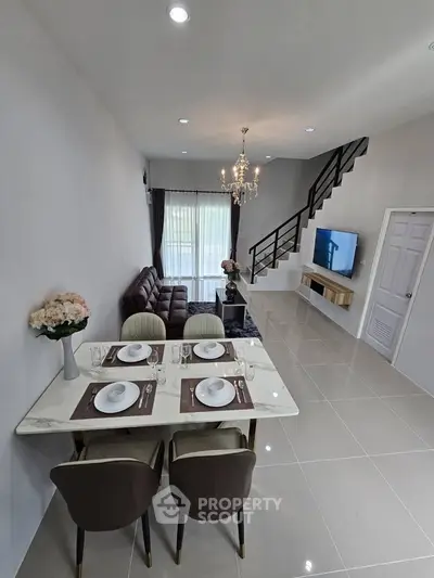Modern living room with elegant dining area and stylish staircase, perfect for contemporary living.