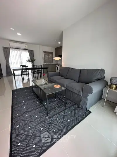 Modern living room with stylish gray sofa and elegant decor in open-plan layout