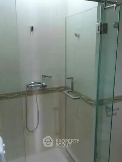 Modern bathroom with glass shower enclosure and sleek fixtures.