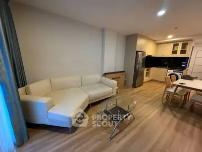 Modern open-plan living room with sleek kitchen and cozy seating area.