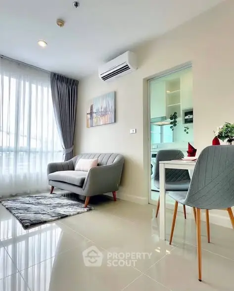 Modern living room with cozy sofa and dining area, featuring large window and air conditioning.