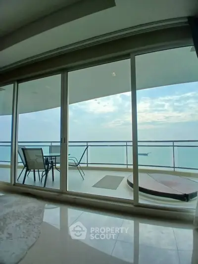 Luxurious balcony with stunning ocean view and modern seating area.
