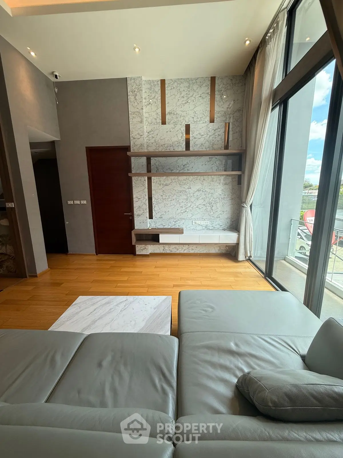 Luxurious modern living room with floor-to-ceiling windows and elegant marble accents.