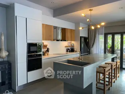 Modern kitchen with sleek design, featuring a large island, built-in appliances, and stylish lighting.