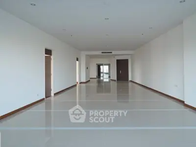 Spacious open-plan living area with modern tile flooring and ample natural light.