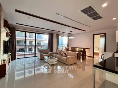 Spacious modern living room with large windows and balcony access in a luxury apartment.