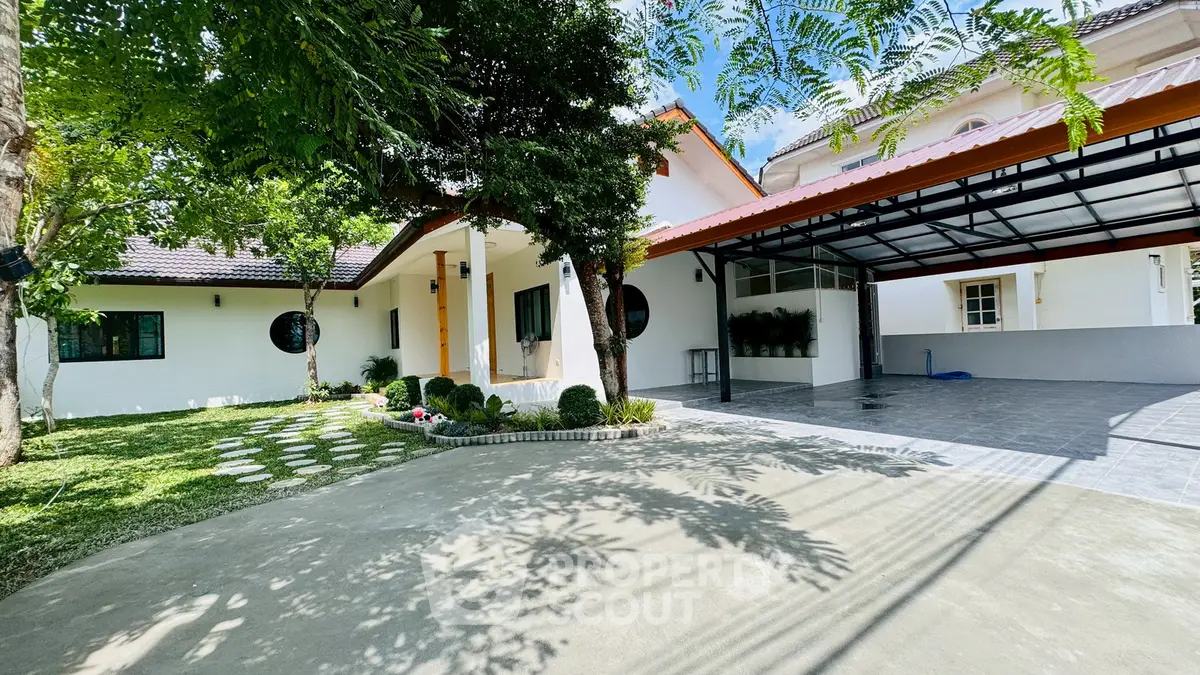 Charming single-story home with spacious driveway and lush garden, perfect for family living.
