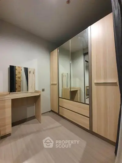 Spacious bedroom with modern wooden wardrobe and dressing table, perfect for stylish storage solutions.