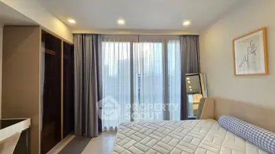 Spacious bedroom with modern decor and large window for natural light