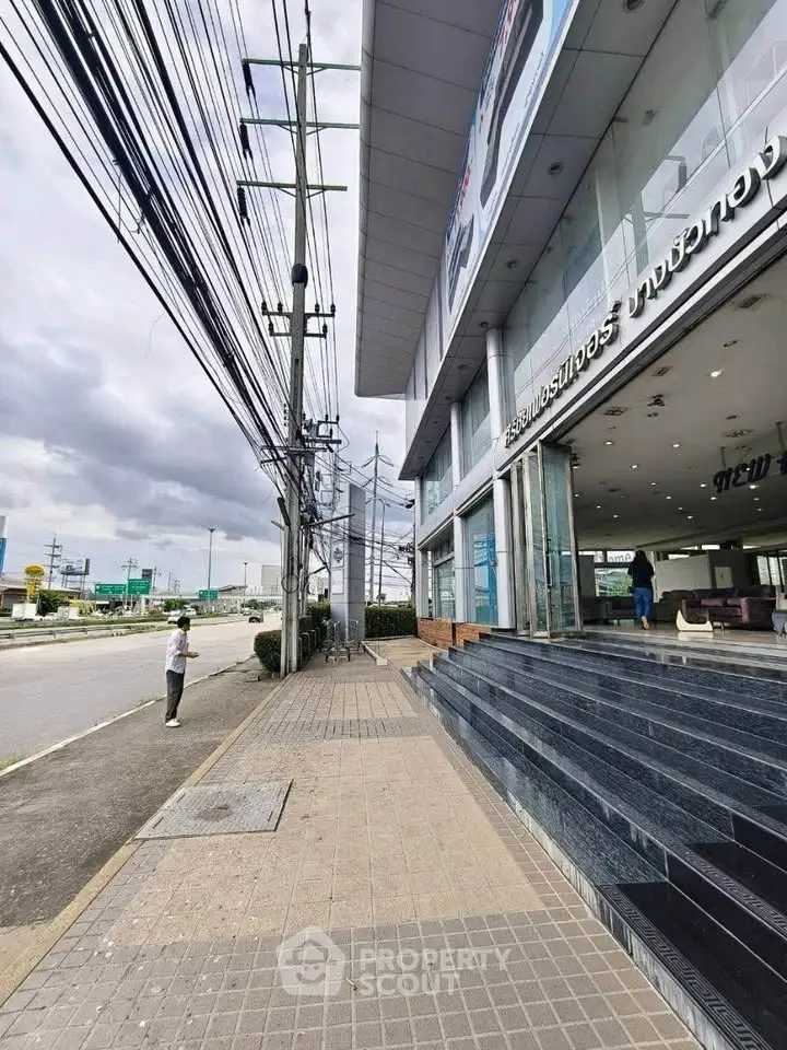 Modern commercial building exterior with glass facade and street view, ideal for business opportunities.