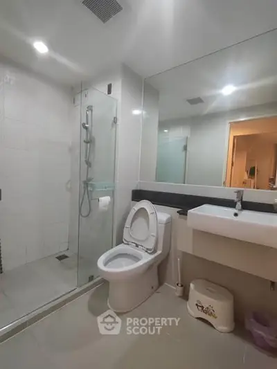 Modern bathroom with glass shower and sleek fixtures in a contemporary home.