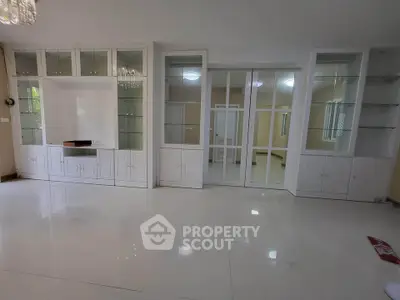 Spacious living room with elegant built-in cabinets and glossy white flooring