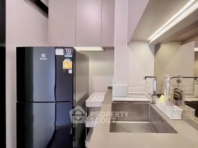 Modern kitchen with sleek black refrigerator and spacious countertop