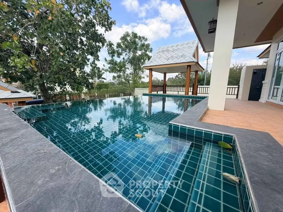 Luxurious outdoor pool with stunning tile design and serene surroundings, perfect for relaxation and entertainment.