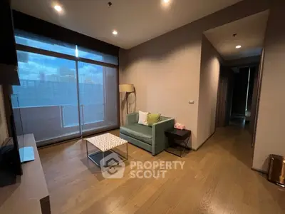 Modern living room with cozy sofa and large window offering natural light.