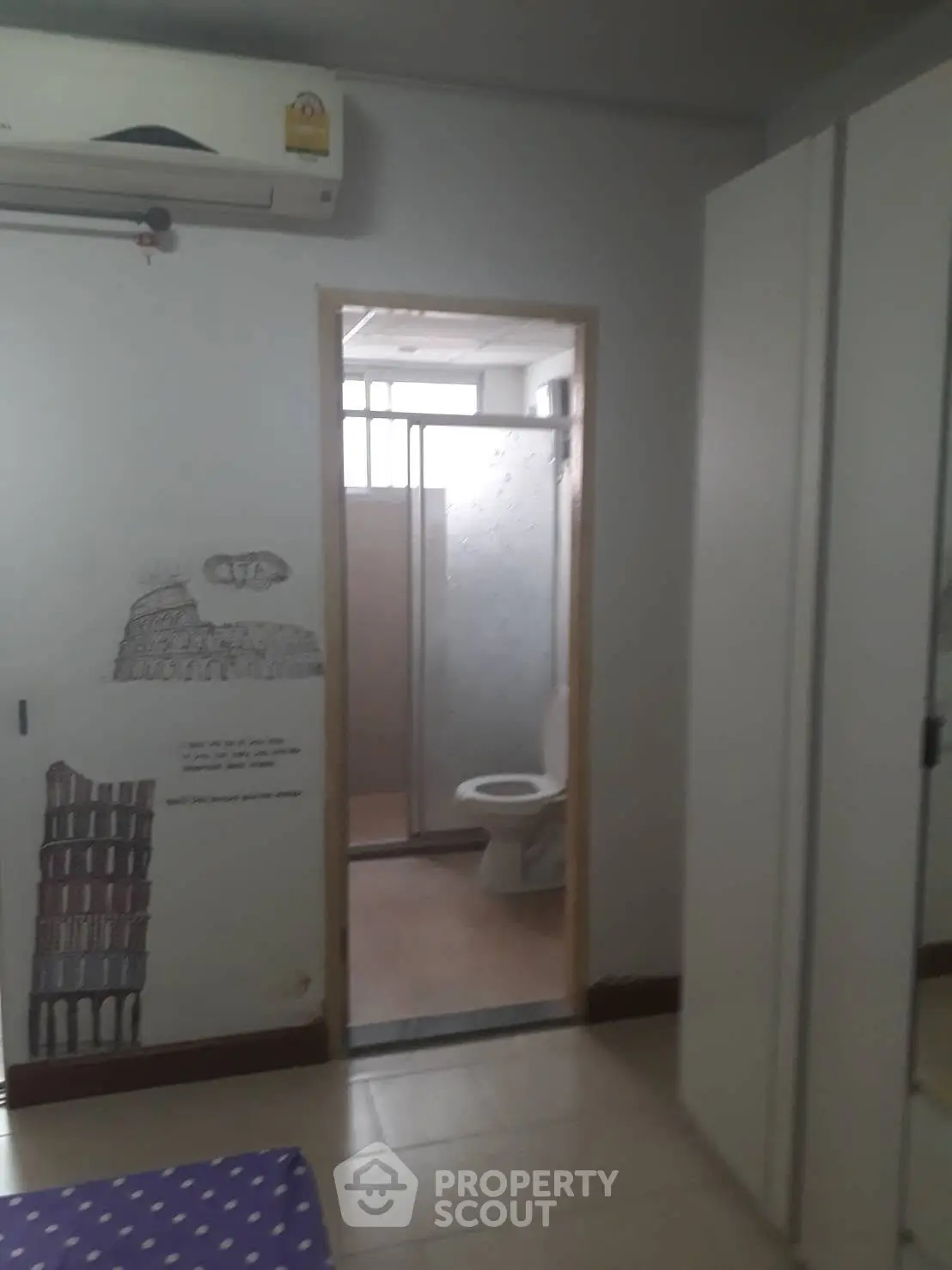 Cozy bedroom with ensuite bathroom and air conditioning in modern apartment.