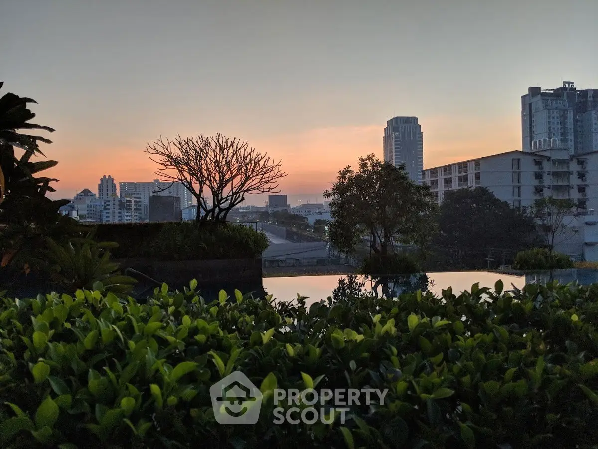 Stunning cityscape view at sunset with lush greenery and skyline backdrop.