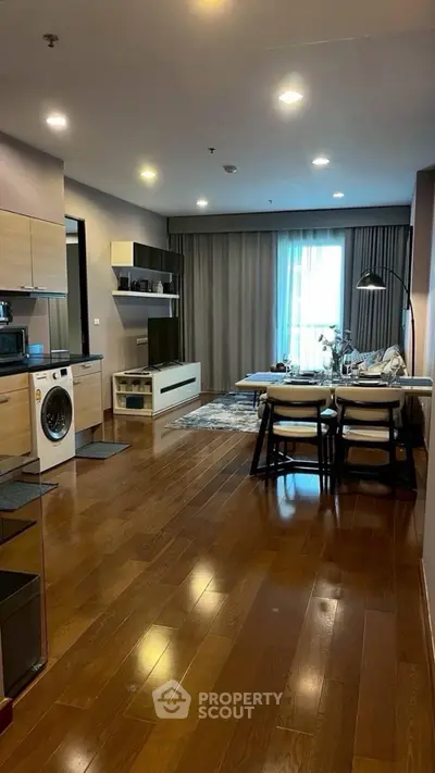 Modern open-plan living room with wooden flooring and stylish furniture