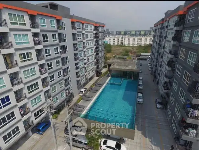 Modern apartment complex with central swimming pool and parking area