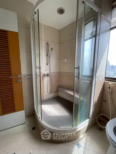 Modern bathroom with glass shower enclosure and city view