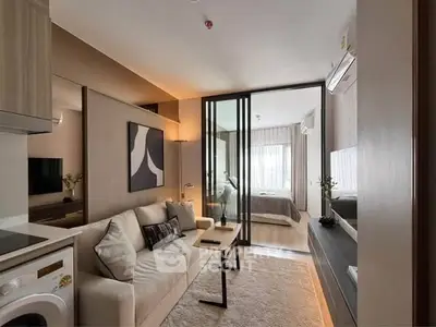 Modern living room with washing machine and cozy bedroom view