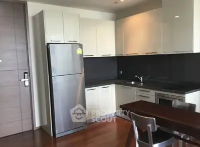 Modern kitchen with sleek cabinetry and stainless steel appliances in a stylish apartment.