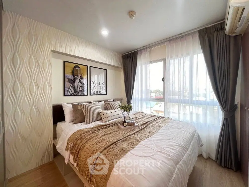 Cozy bedroom with stylish decor and large window for natural light.