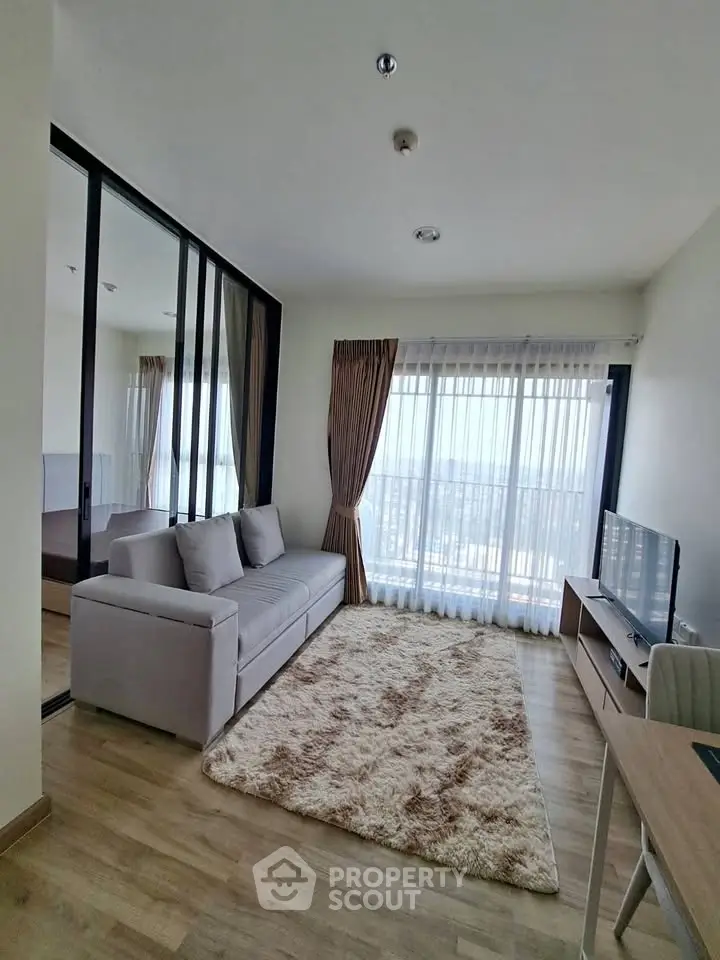 Modern living room with large windows and cozy decor in a stylish apartment.