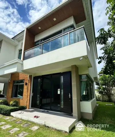 Modern two-story house with large windows and lush garden