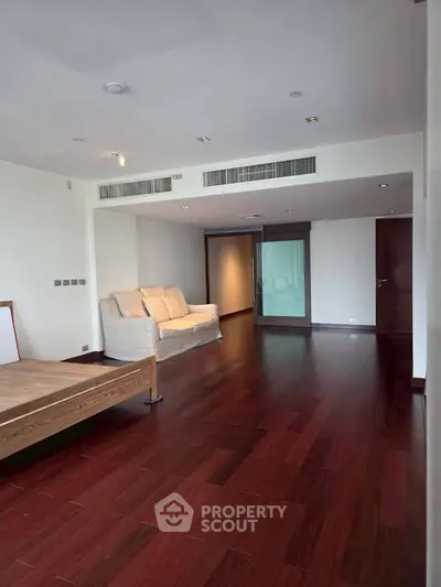Spacious living room with wooden flooring and modern design in luxury apartment.