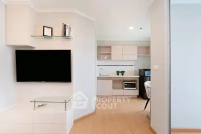 Modern living room with sleek TV setup and open kitchen layout
