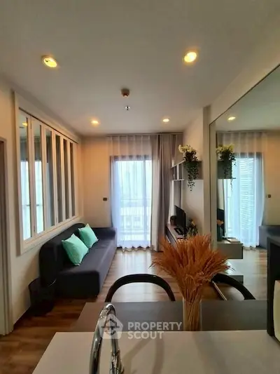 Modern living room with cozy sofa, large window, and stylish decor in a contemporary apartment.