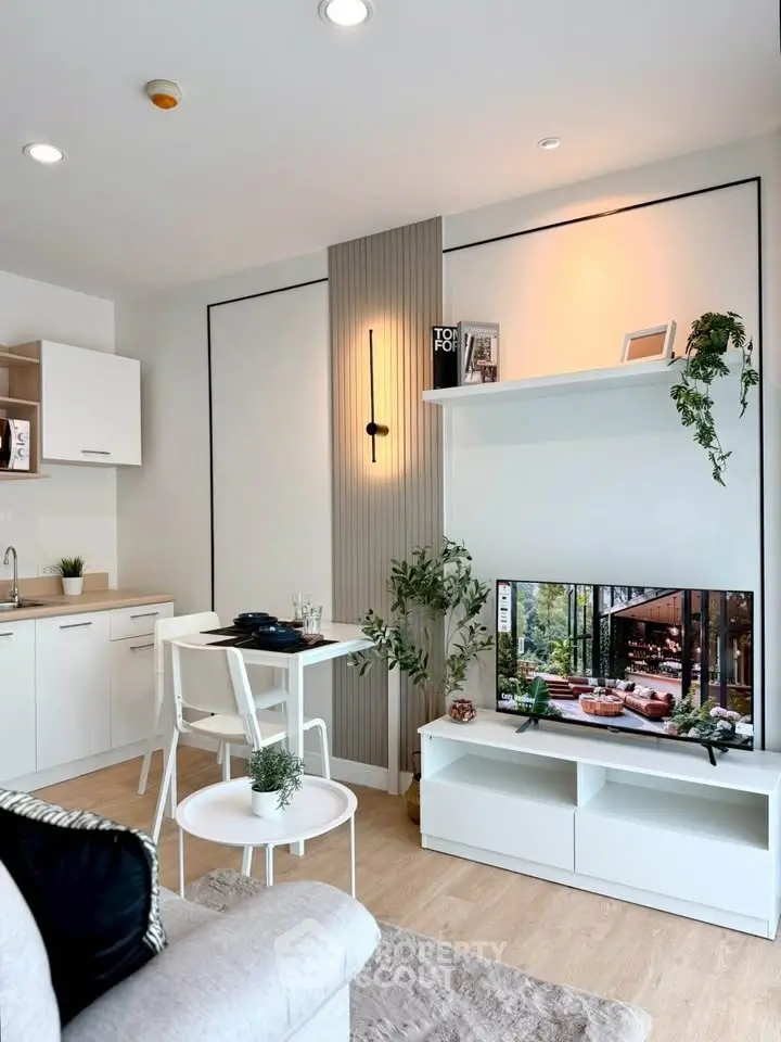 Modern living room with stylish decor and open kitchen layout, featuring sleek furniture and natural lighting.
